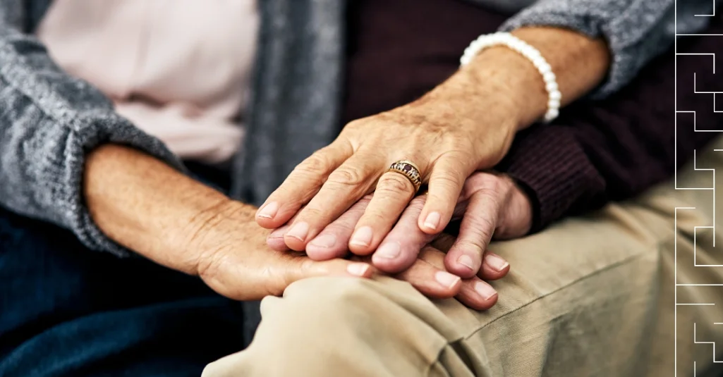 Two older people holding hands
